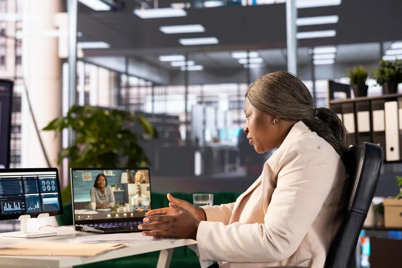 Деловая женщина просматривает графики выручки компании во время видеозвонка с сотрудниками.
